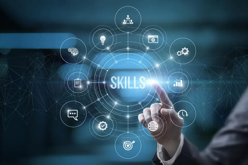 Skills Employers Look For concept image showing a businessperson’s hand in a suit pointing at a glowing digital interface with the word ‘SKILLS’ in the center, surrounded by circular icons representing communication, teamwork, leadership, analytics, target setting, creativity, and technology on a blue blurred background symbolizing modern workforce requirements