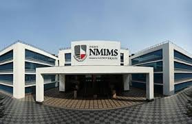 NMIMS campus main entrance image showing a modern white building with glass wings on both sides, central portico, and prominent NMIMS University logo and name displayed above the entryway.