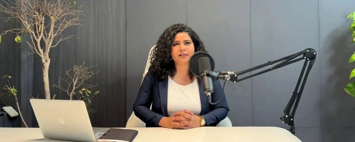 Career Plan B founder recording a video podcast with a professional microphone and laptop in a studio.